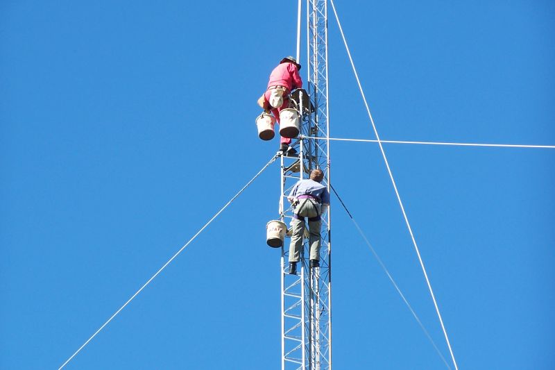 Paul WØAIH and Chris KC9DGP inserting mast into rotor plate and bearing.