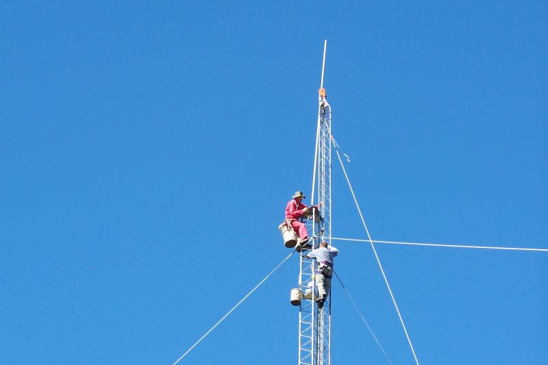 Paul WØAIH and Chris KC9DGP inserting mast into rotor plate and bearing.