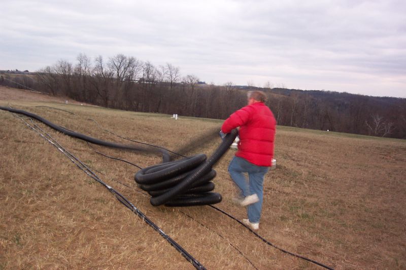 Dick K0MN rolling out 4 inch drain tile that will be buried in trench.